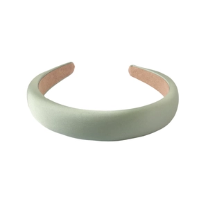 Détail d'un serre-tête rembourré en satin vert clair avec doublure antidérapante