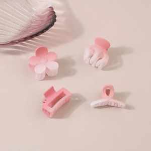Détail d'un lot de quatre pinces à cheveux rose dégradé aux formes fleurs et géométriques