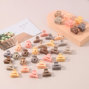 Mini hair clips in matte macaron colors and various shapes on a geometric display