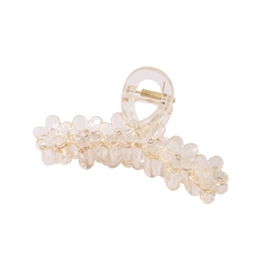 Detail view of the transparent floral hair claw clip showing acrylic texture and gold spring