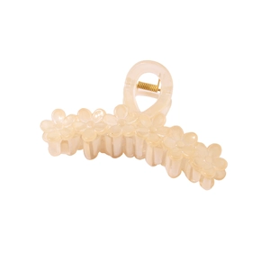 Detail view of large cream flower hair claw clip with sturdy gold spring and floral relief