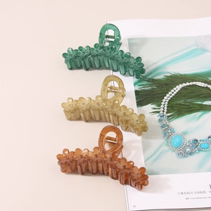 Three-piece floral hair claws in green, amber, and brown acrylic with high-gloss finish