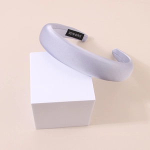 Detailed macro view of light purple satin headband showing the hand made label and texture