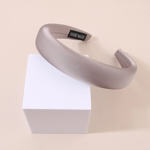 Close-up of premium satin headband with high-gloss finish and handmade label detail