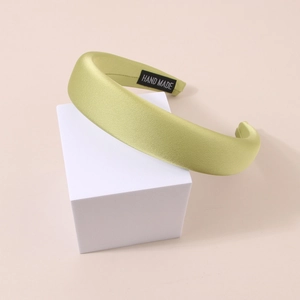 Close-up of handmade avocado green satin headband with thick sponge padded texture
