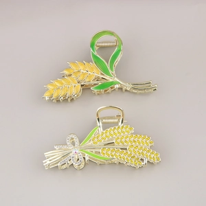 Détail de pinces à cheveux blé doré avec feuilles en émail et strass jaunes étincelants