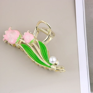 Détail de la pince à cheveux tulipe avec fleurs en émail rose, métal doré et perle
