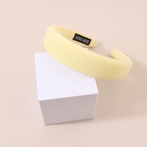 Detail of light yellow sponge headband with twill texture and Hand Made label on it