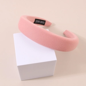 Detail of pink padded sponge headband featuring a hand made tag and knit texture