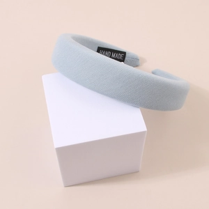 Detail of light blue padded sponge headband with handmade label and twill fabric texture
