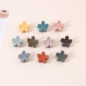 Set of 10 colorful mini floral hair claw clips in various pastel shades on beige background