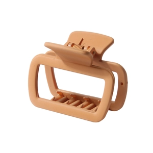 Detailed macro view of large peach rectangle hair claw clip with matte finish and metal spring