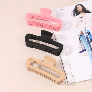 Detailed view of matte rectangle hair claws in pink, black, and beige colors