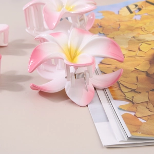 Pince à cheveux fleur de frangipanier avec dégradé rose et blanc et centre jaune