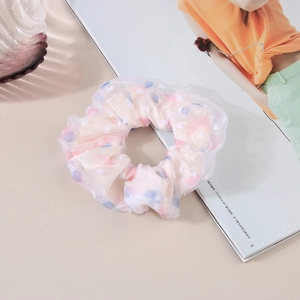 Macro detail of high-elasticity mesh heart scrunchie with layered organza and dot pattern