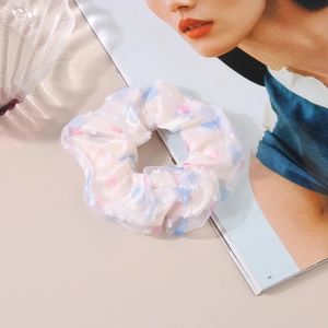 Detailed close-up of floral mesh scrunchie with soft pink and blue organza textures