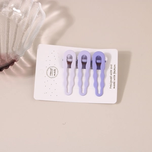 Three-piece set of purple matte wavy hair clips on a handmade display card for styling