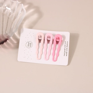 Detailed view of three pink gradient wave hair clips on white card with frosted finish