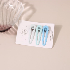 Detailed view of three-piece gradient blue metal hair clips on a white display card