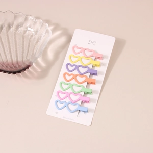 Set of 7 heart-shaped hollow hair clips in various macabre colors on a display card