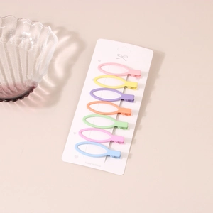 Close-up of seven colorful matte finish hair clips in macrame pastel colors on card