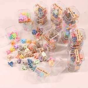 Detailed view of mini macaron colored hair claws in various shapes with a gift box