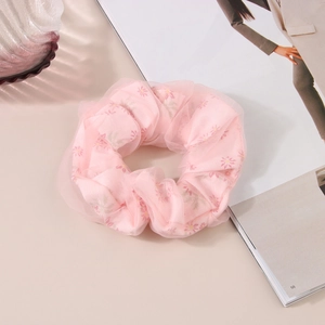 Détail d'un chouchou rose à fleurs avec tissu en tulle double couche et haute élasticité