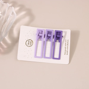 Set di tre fermagli per capelli viola opachi rettangolari su cartoncino bianco