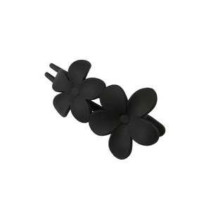 Macro detail of matte black floral hair clip with twin five-petal flower design