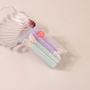 Detail view of purple and mint green hair root clips for volume in transparent box