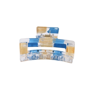 Detail view of transparent rectangular hair claw with blue and gold foil texture