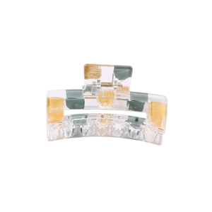Detailed close-up of large geometric hair claw clip with amber resin marble patterns