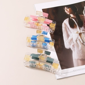 Three geometric acrylic hair claws with colorful artistic paint strokes and gold foil accents