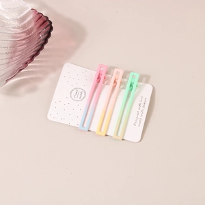 Détail des barrettes à cheveux dégradé macaron sur une carte décorative faite main