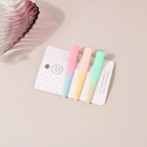 Gros plan de trois barrettes à cheveux mates dégradées macaron sur carte de support