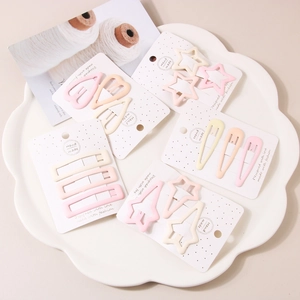 Detail of macaron-colored matte hair clips in heart, star, and waterdrop shapes