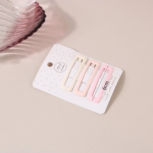 Three-piece matte cream rectangle hair clips set on handmade paper card detail