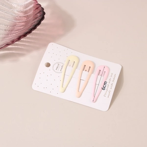 Close-up of three 6cm matte metal water-drop hair clips in cream pastel colors on card