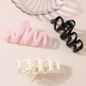 Three wavy resin hair claws in pink, black, and cream beige colors for elegant styling
