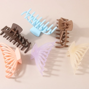 Grandes pinces à cheveux mates de style requin en six couleurs sur un fond beige neutre