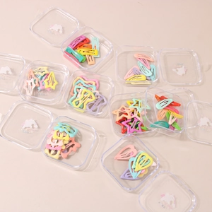 Detail view of colorful candy-colored star hair clips in transparent storage boxes