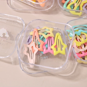 Macro shot of colorful star-shaped hair clips in a transparent storage box
