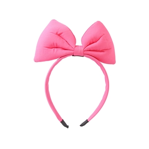 Close-up of bright pink oversized fabric bow headband with soft texture and protective tips