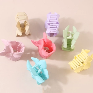Matte butterfly hair clips in pastel colors including beige, lavender, and mint green
