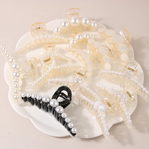 French vintage pearl hair clips and resin shark claw clips on a white ceramic tray