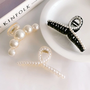 French vintage pearl hair claw clips set in various designs on a white ceramic plate
