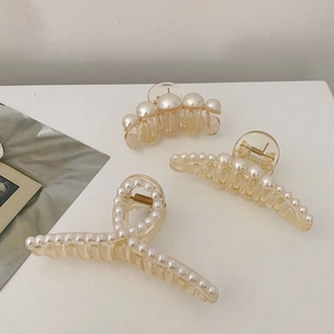 Three amber resin hair claws with faux pearls in large, medium, and small sizes