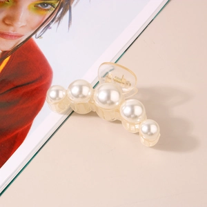 Detail view of large French retro pearl hair claw clip with transparent resin and metal spring