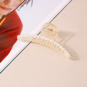 Macro detail of French retro hair claw clip with cream pearls and elegant transparent finish