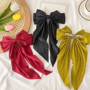 Elegant French satin ribbon bow hair clips in black, burgundy and yellow on a white background